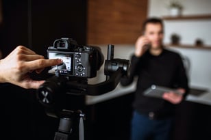 cameraman-s-finger-point-on-camera-s-screen-recording-video-or-taking-picture-of-young-businessman-in-kitchen-talking-on-phone-hold-laptop-and-work-remote-has-own-business-blurred-wall